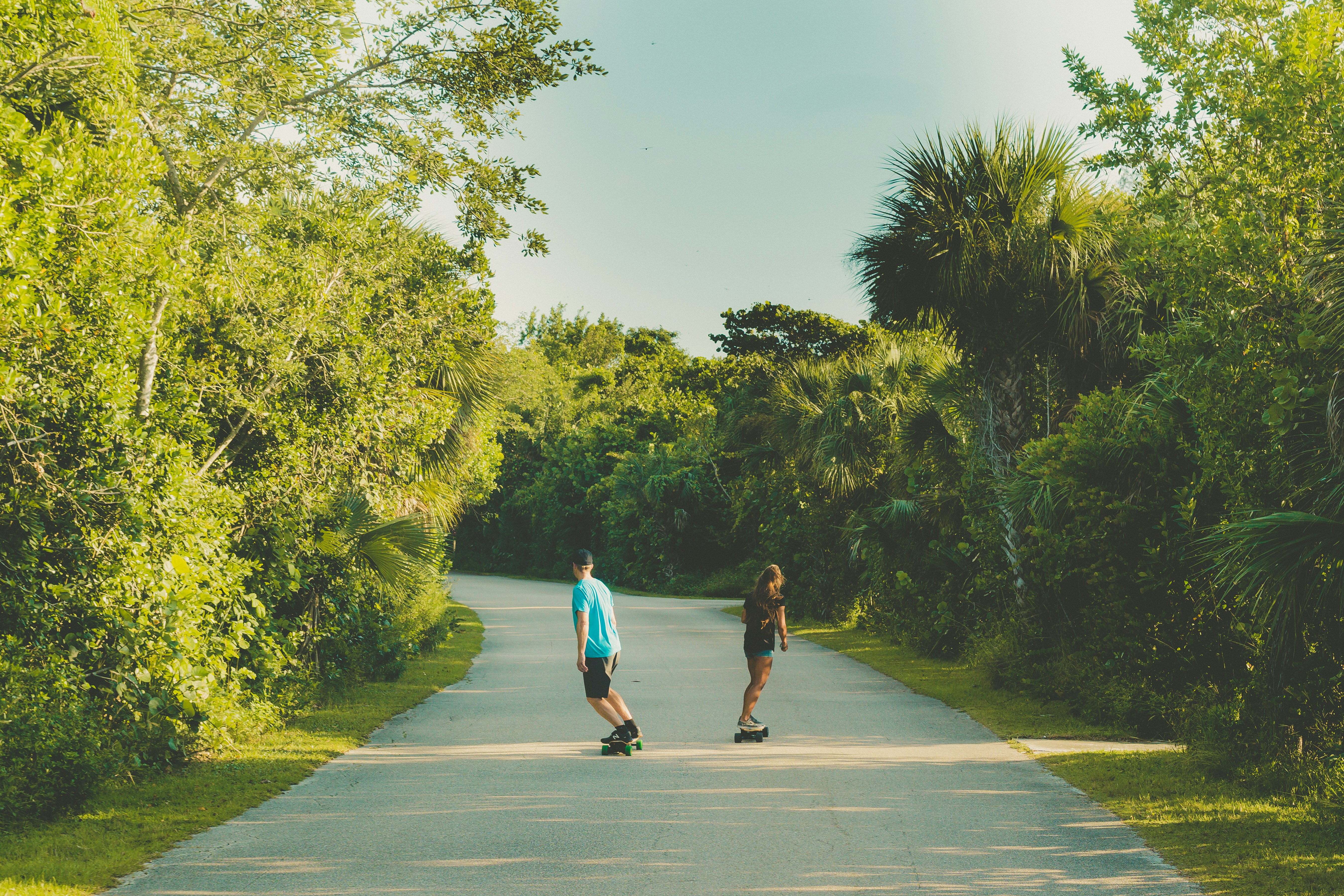 shallow focus photo of two person riding skateboards during daytime